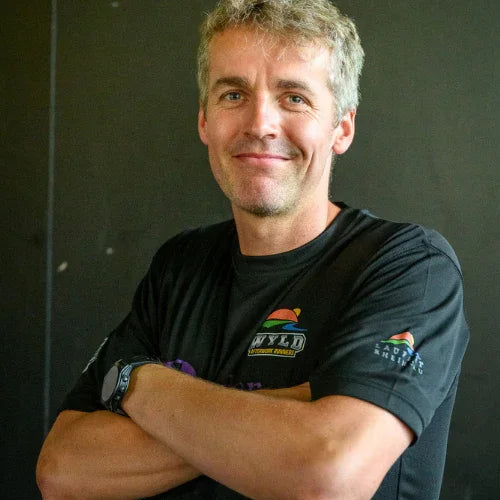 Lächelnder Mann mit WYLD Charity Run Laufshirt, schwarzer Hintergrund, Sportevent Rheingau